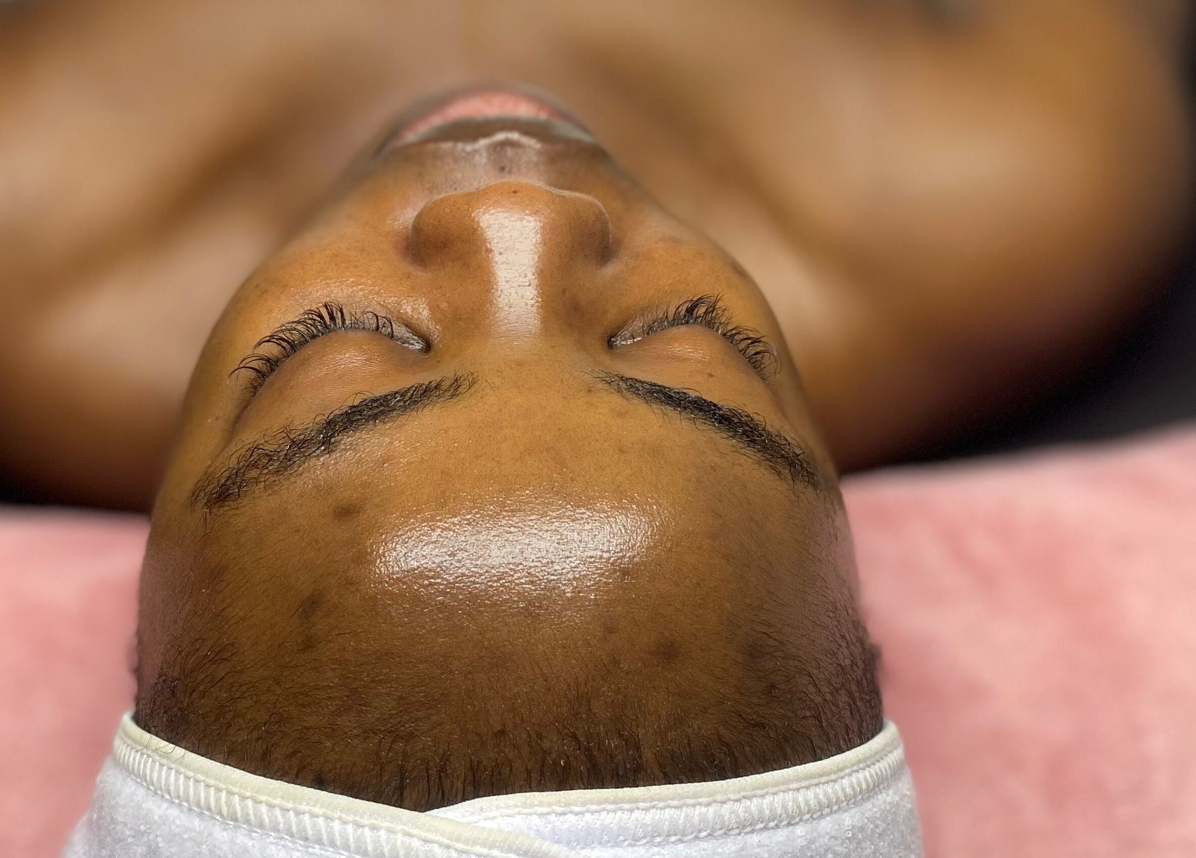 Soins visage relaxants chez Aesthetic by Maskara à Port-au-prince, Ouest, HT, sur une serviette rose.