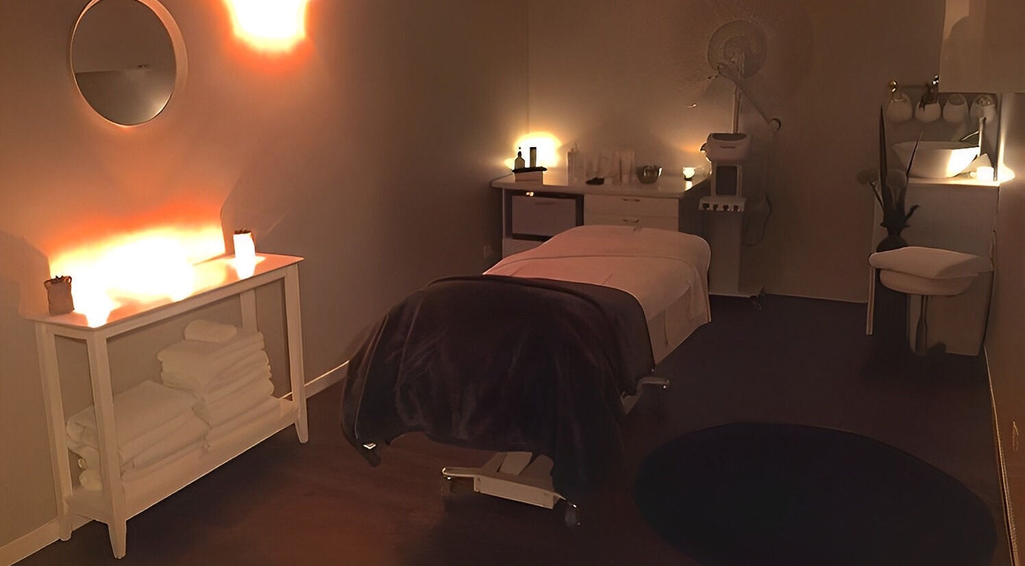 Relaxing massage room at Nourish Spa and Skin Clinic, Melbourne, VIC, AU with warm lighting and cozy decor.