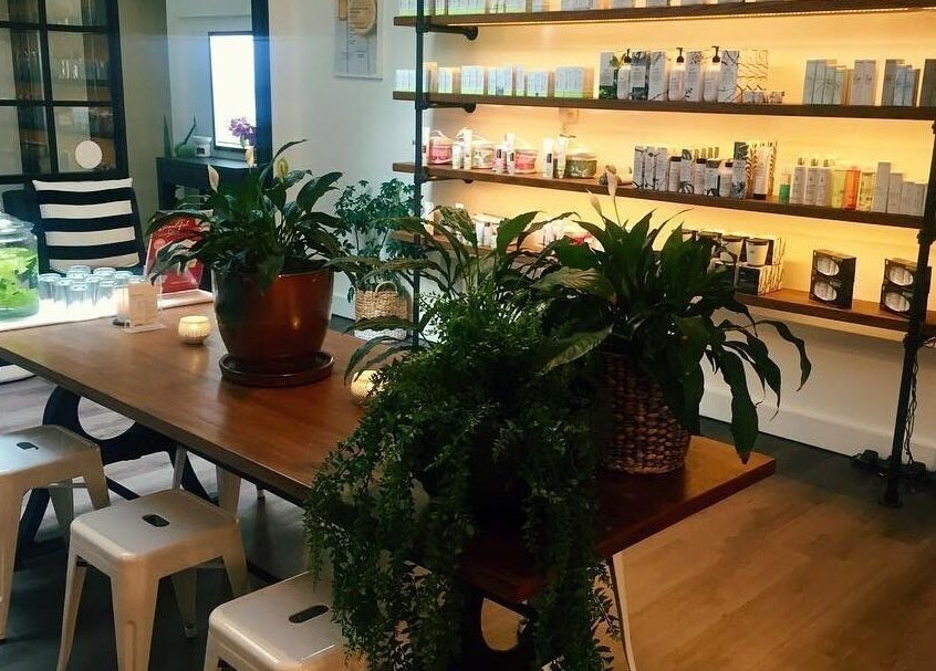 Cozy lounge at Nourish Spa and Skin Clinic, Melbourne, VIC, AU, featuring lush plants and product shelves.