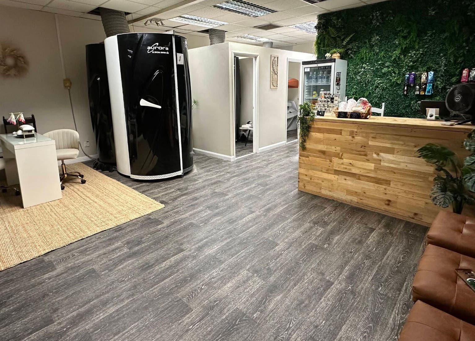 Inside Premier Tanning in Brigg, England, GB, with a sleek tanning booth and cozy seating area.