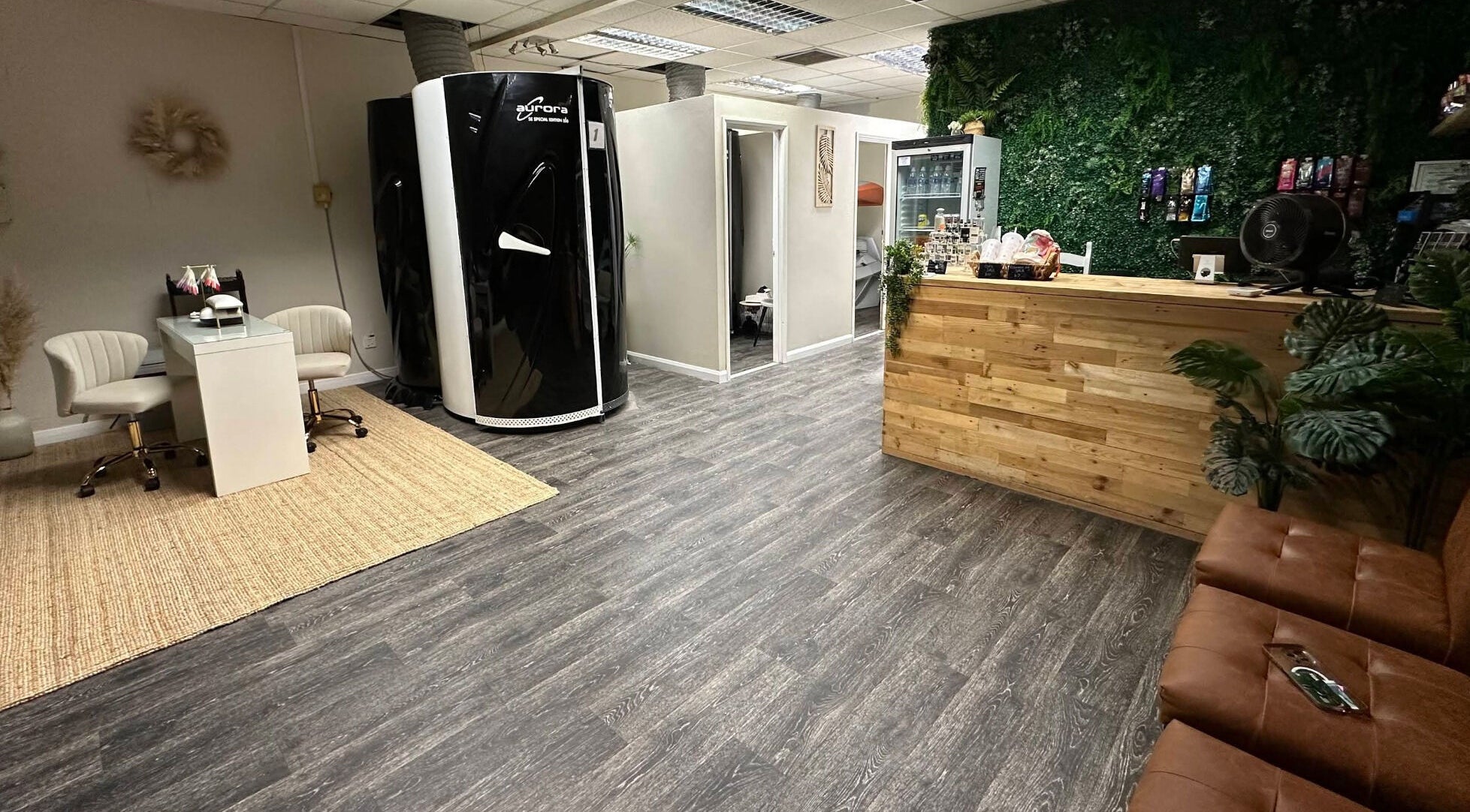 Inside Premier Tanning in Brigg, England, GB, with a sleek tanning booth and cozy seating area.