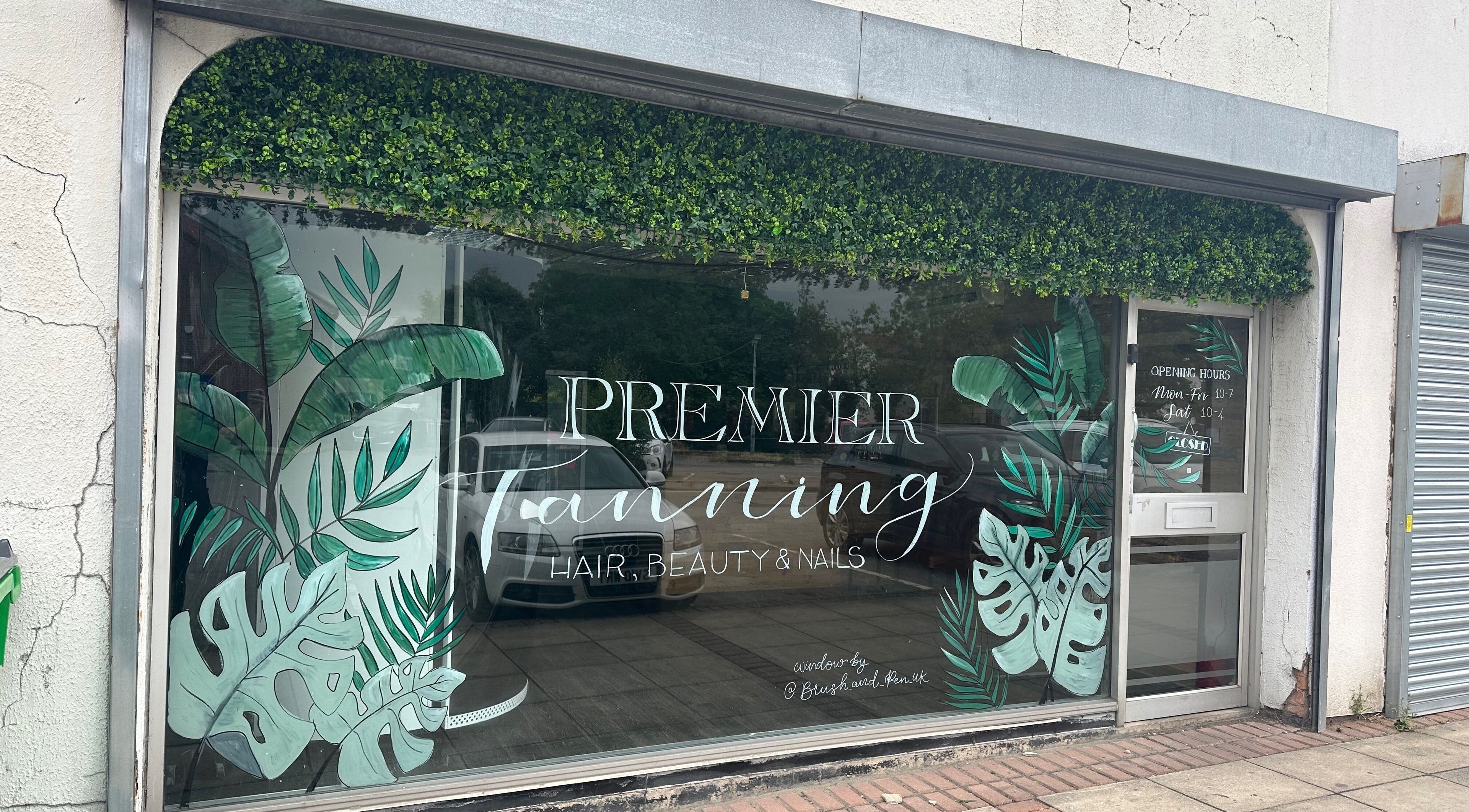 Premier Tanning storefront with vibrant green leaf decor, located in Brigg, England, GB.