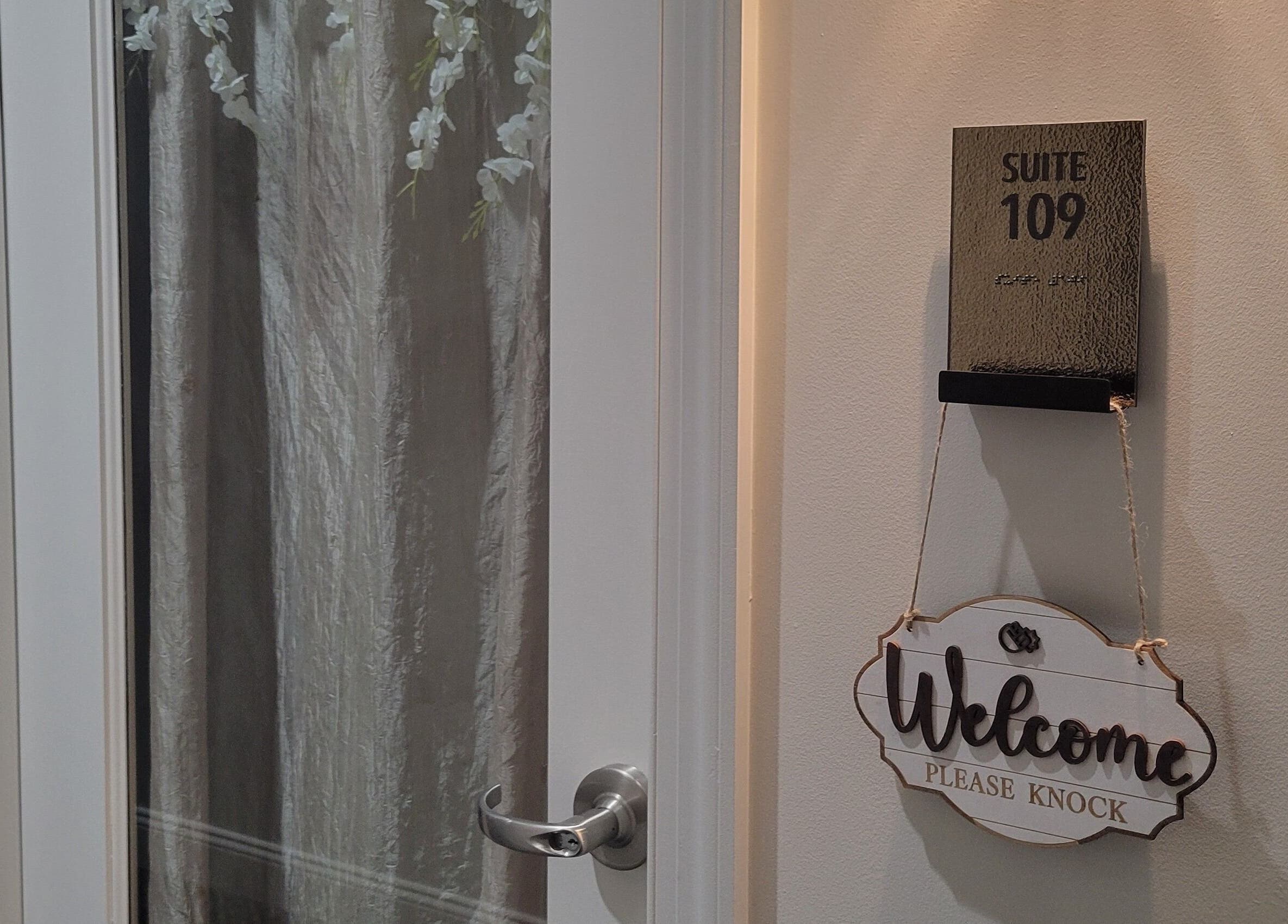 Entrance of Taylored Spa and Massage in Bayonne, New Jersey, US, with 'Welcome Please Knock' sign.
