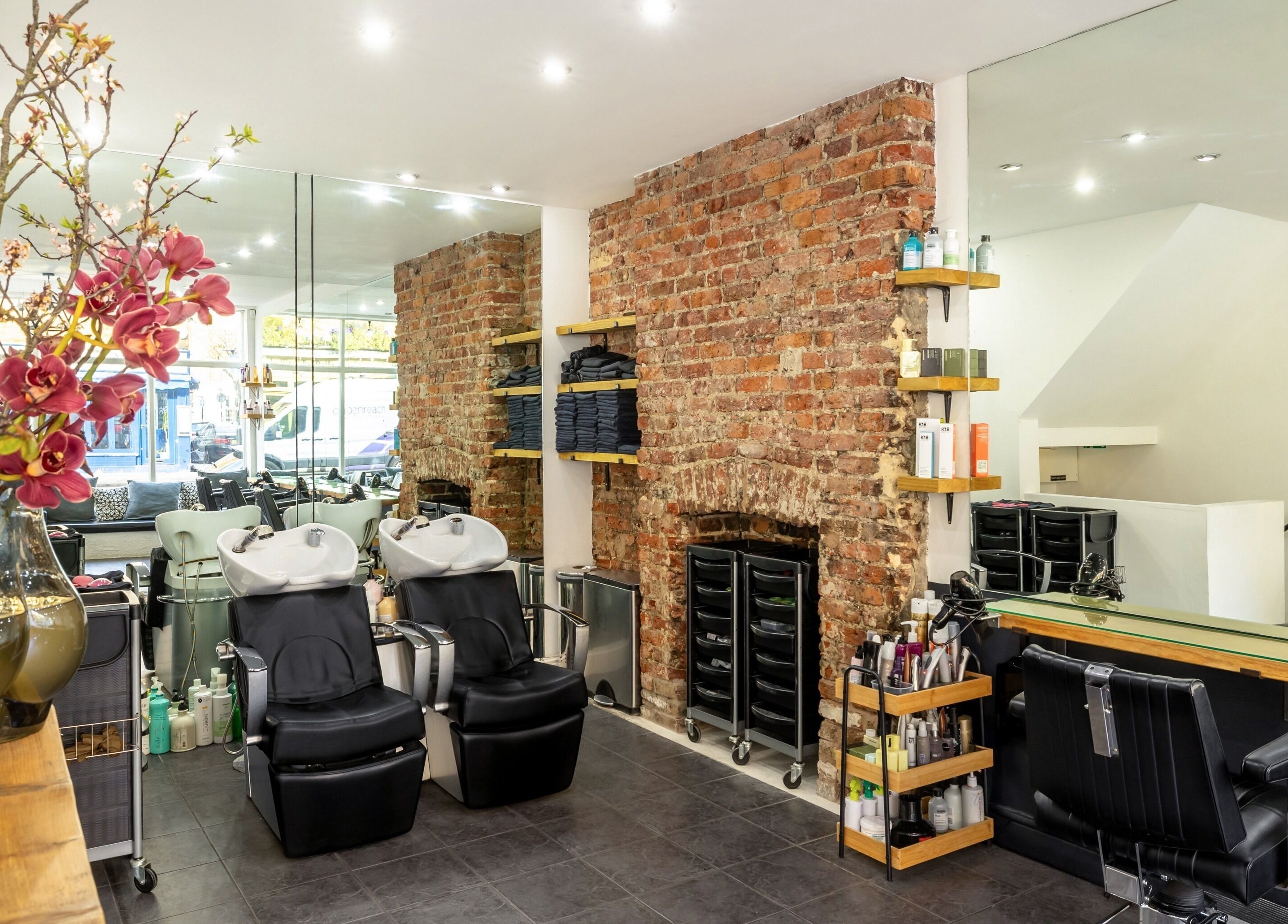 Interior of Hikari Salon in London, England, GB, featuring elegant styling stations and exposed brick wall.