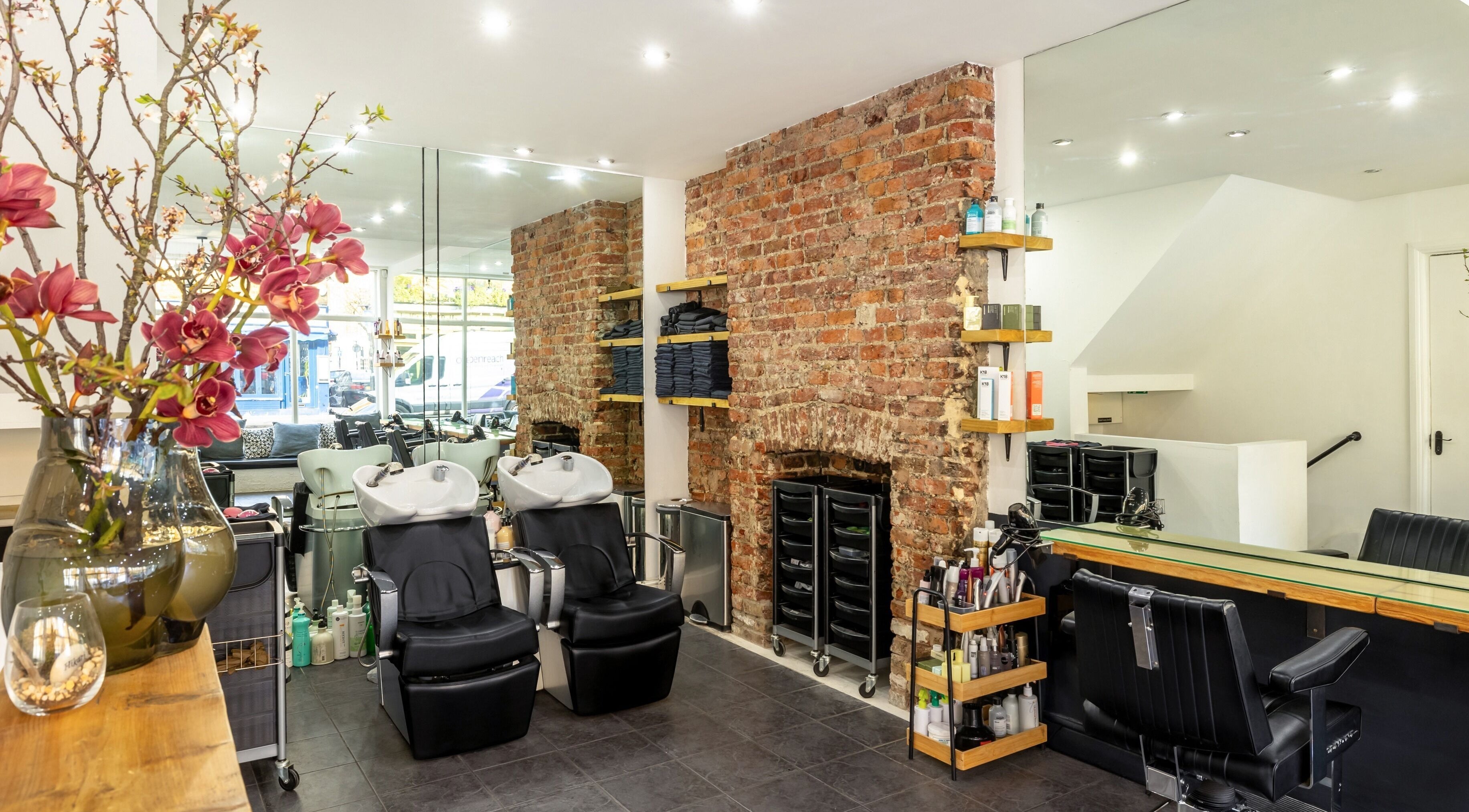 Interior of Hikari Salon in London, England, GB, featuring elegant styling stations and exposed brick wall.