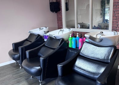 Chic hair wash stations at Hair by Emma at Xclusive, Bournemouth, England, GB, featuring modern black chairs.