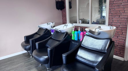 Chic hair wash stations at Hair by Emma at Xclusive, Bournemouth, England, GB, featuring modern black chairs.