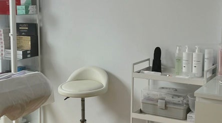 Serene corner of Kati Aesthetics in London, England, GB with a plush chair and skincare products neatly arranged.