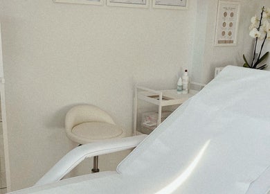 A calming treatment room at Kati Aesthetics, London, England, GB, featuring a reclining chair and organized shelf.