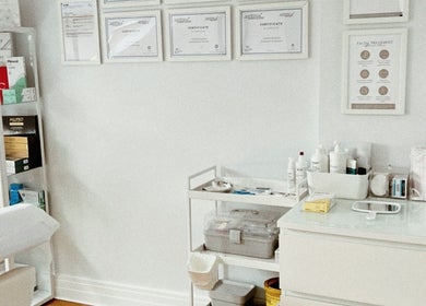 Bright and organized treatment space at Kati Aesthetics in London, England, GB with display shelves and certificates.