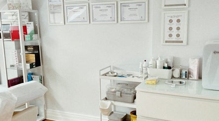 Bright and organized treatment space at Kati Aesthetics in London, England, GB with display shelves and certificates.