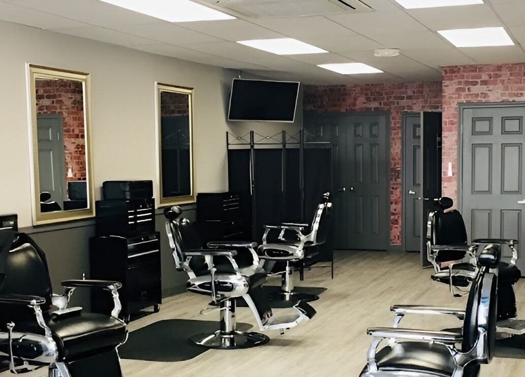 Interior of In the Cut Barbershop, Long Beach, California, showcasing sleek black chairs and modern decor.