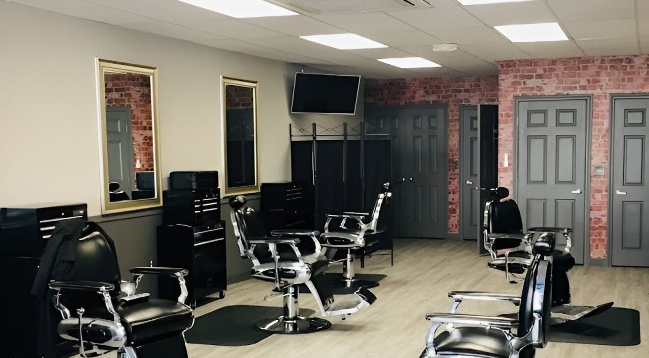 Interior of In the Cut Barbershop, Long Beach, California, showcasing sleek black chairs and modern decor.