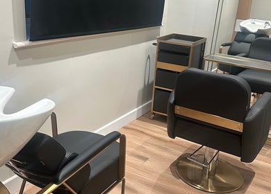 Contemporary hair salon interior at GlamTress✨, featuring stylish chairs and a mirror setup in Luton, England, GB.