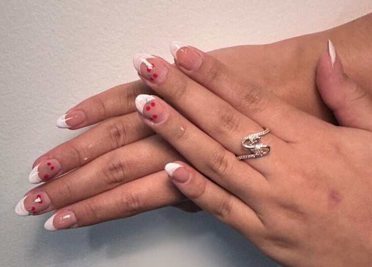 Manucure française élégante chez Éternails, Montréal, Québec, CA, avec design de fleurs rouges.