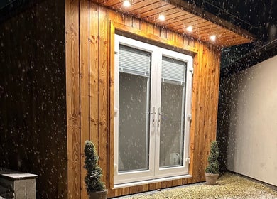 Exterior of Kadi Hartley Beauty in Penistone, England, GB at night, featuring illuminated wooden facade.