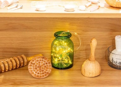 Warm ambiance at Sy Relax Massage & Wellness, Amsterdam, Noord-Holland, NL with wooden tools and a glowing jar.