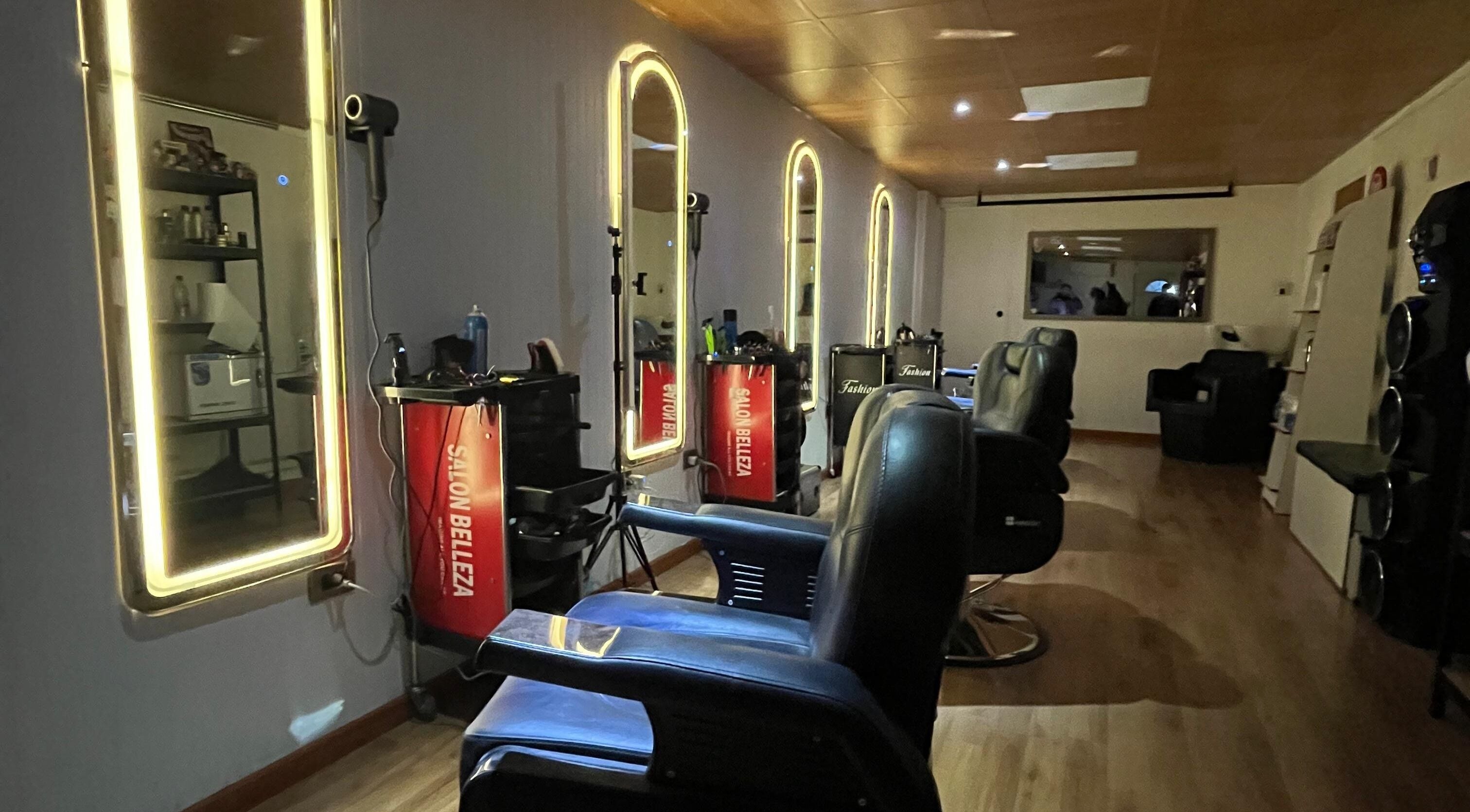 Espacio moderno en Essencial Estudio, Temuco, Araucanía, CL con espejos iluminados y sillas de barbería.