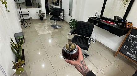 Interior de Jyc Studio en La Plata, Buenos Aires, AR con silla de barbero y mate en primer plano.