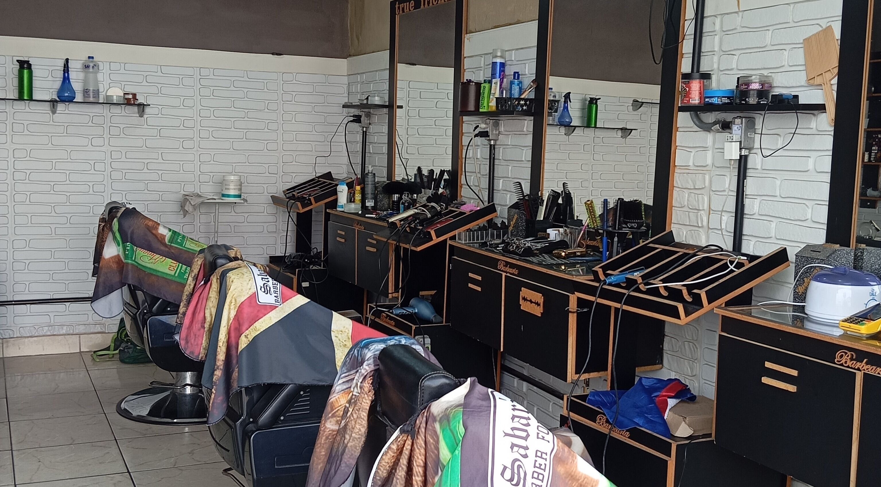 Interior da Barabearia 24 de Fevereiro em São Paulo, São Paulo, BR, com cadeiras e equipamentos de barbearia.