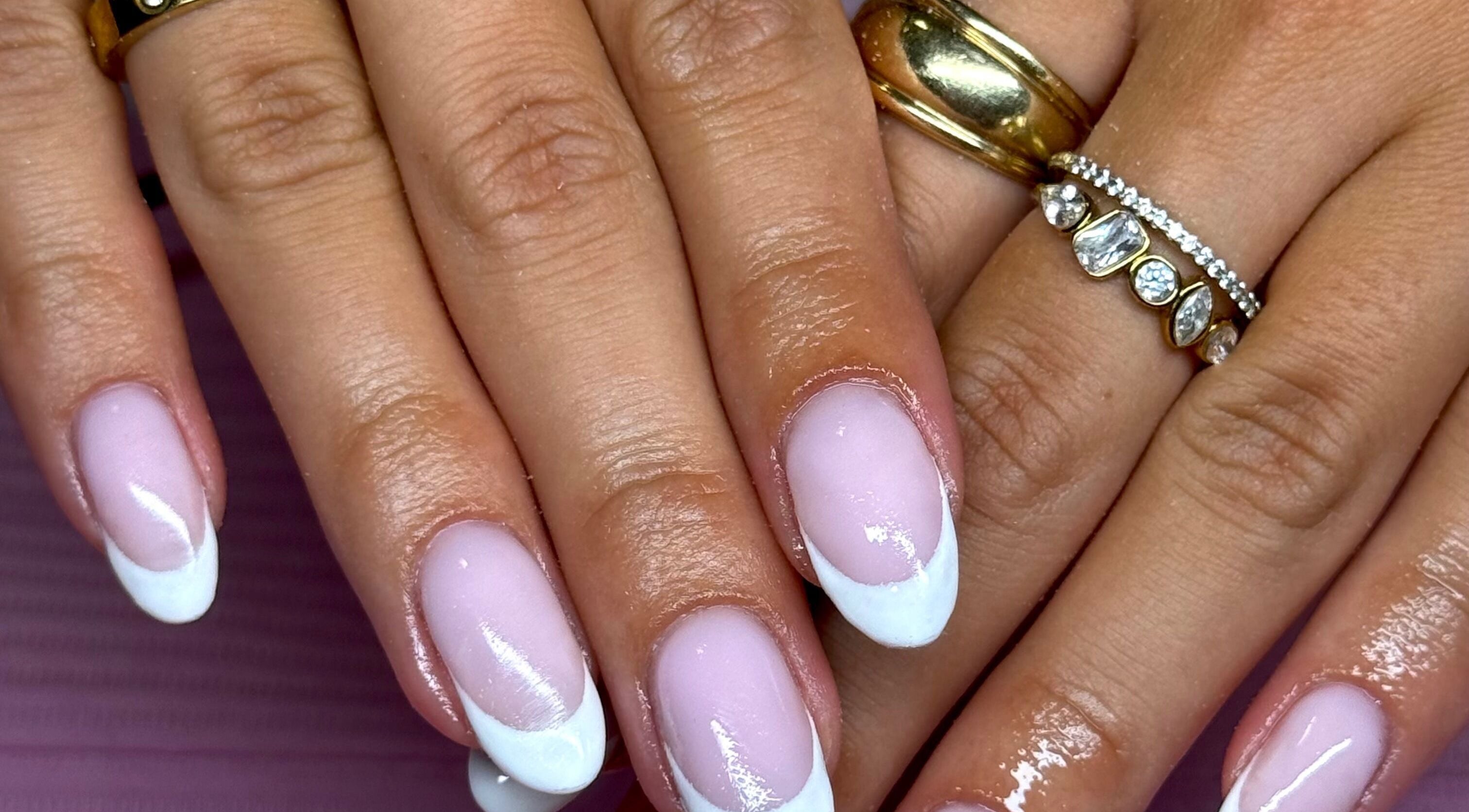 Elegant French manicure at Nails by Eden, Murrumba Downs, Queensland, AU. Gold layered rings enhance the style.