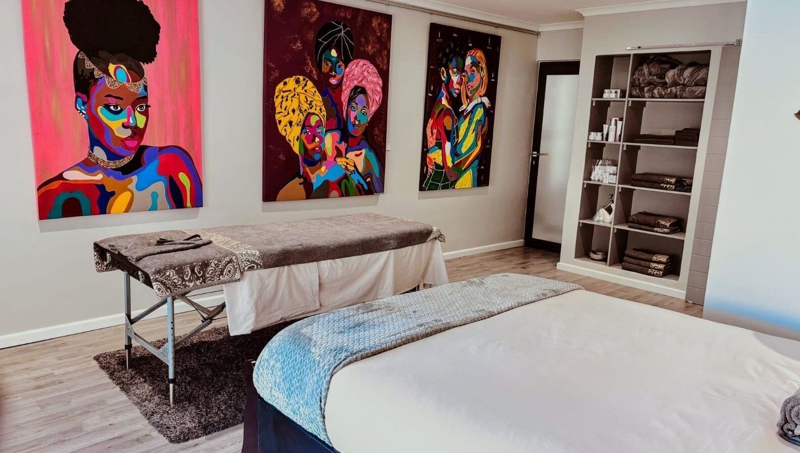 Massage room at Chalila Wellness, Cape Town, with vibrant art and cozy decor.
