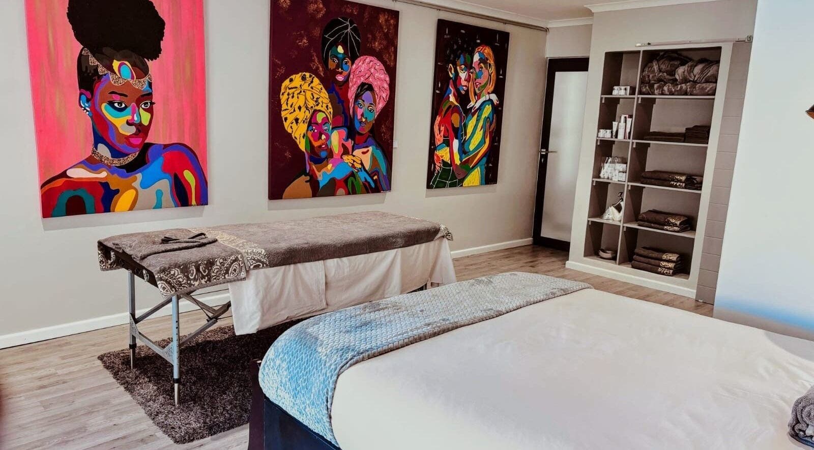 Massage room at Chalila Wellness, Cape Town, with vibrant art and cozy decor.