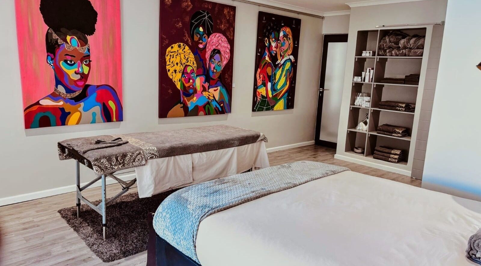 Massage room at Chalila Wellness, Cape Town, with vibrant art and cozy decor.