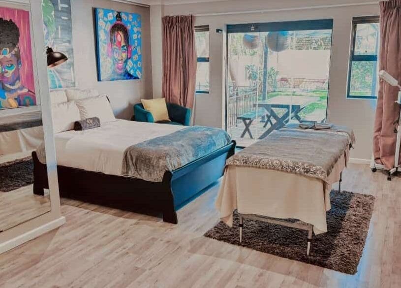Bright massage room at Chalila Wellness in Cape Town, Western Cape, ZA with colorful art and cozy setup.