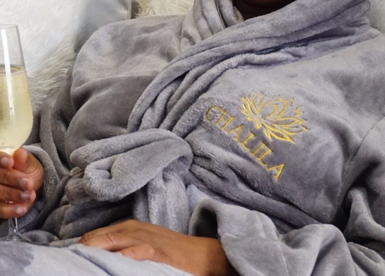 Person in soft robe with Chalila Wellness logo enjoying a drink in Cape Town, Western Cape, ZA.