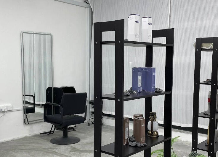 Modern interior of PLAN A HAIR SALON in Masai, Johor, MY featuring stylish black shelves and elegant salon chair.