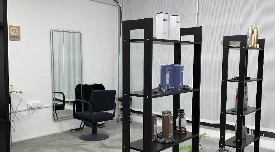 Modern interior of PLAN A HAIR SALON in Masai, Johor, MY featuring stylish black shelves and elegant salon chair.