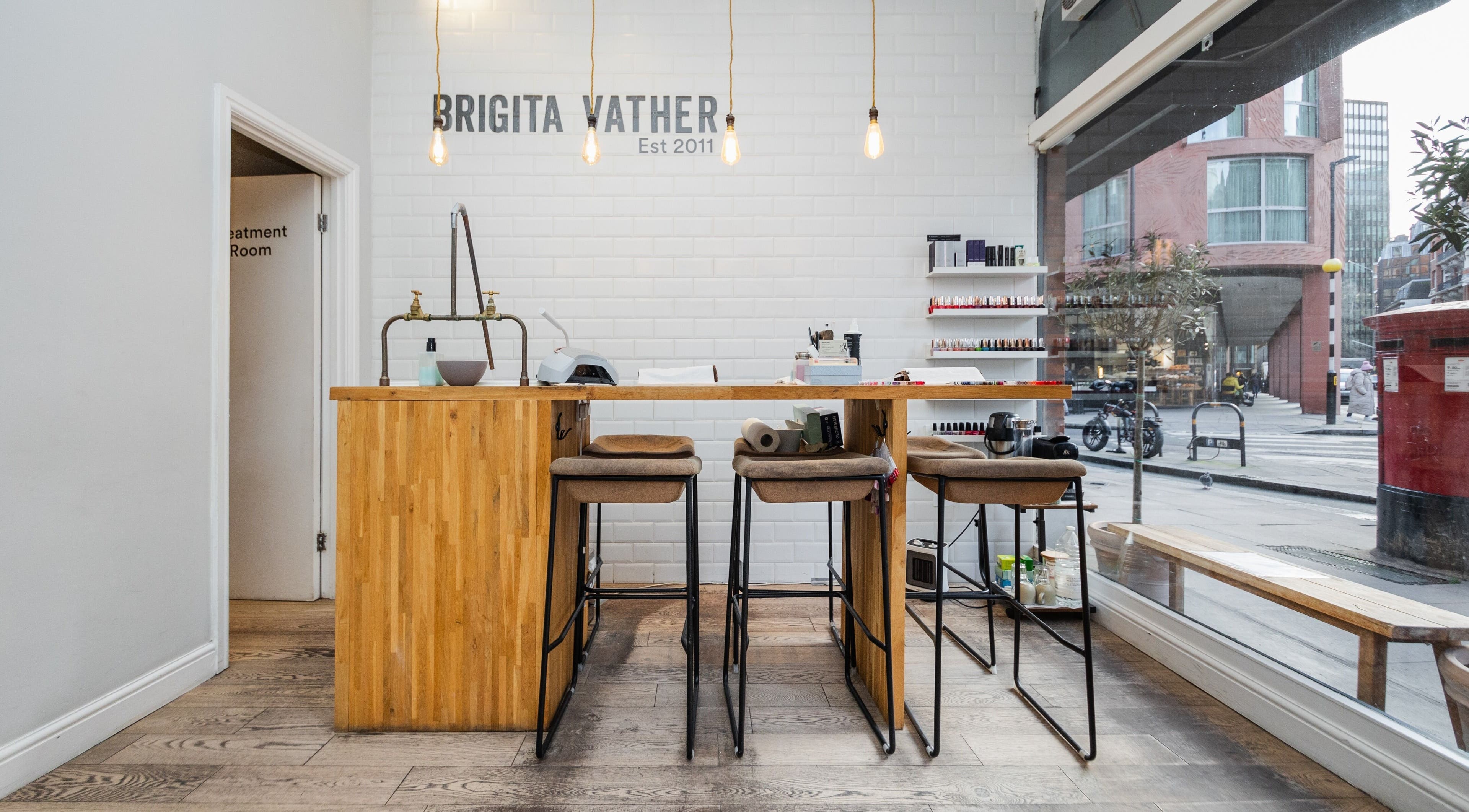Chic and modern interior of Brigita Vather salon in London, England, GB, featuring stylish bar stools and nail polish display.