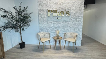 Elegant seating area at Piko’s Skin Care in Sarasota, Florida, US featuring two chairs and a table with decor.