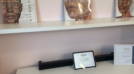 Interior view of KalliJayne Aesthetics in Margate, England, showcasing educational facial anatomy diagrams on a shelf.