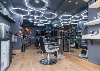 Modern barber interior at PLAN B | BALLUTA in Sliema, MT with stylish seating and hexagonal lighting.