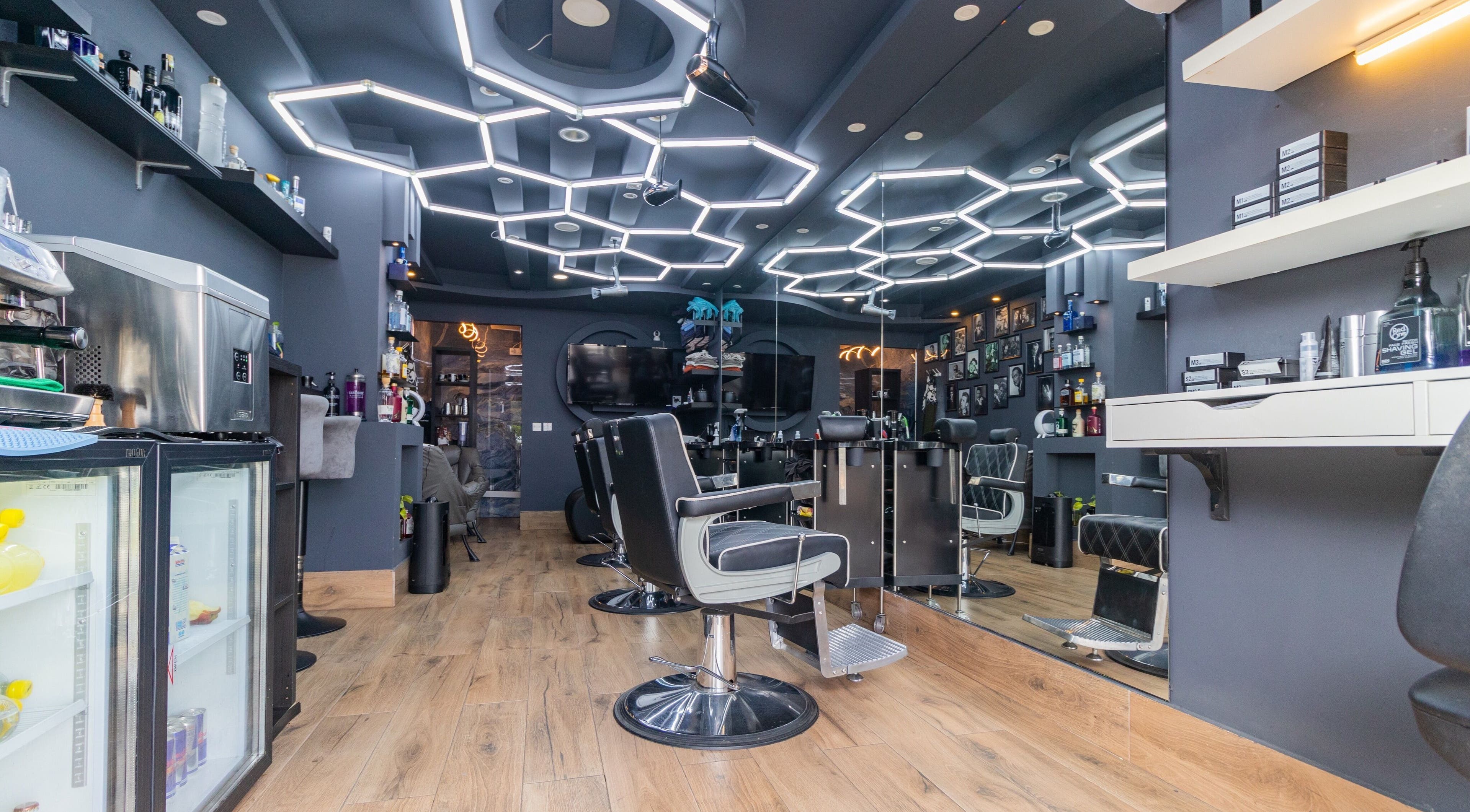 Modern barber interior at PLAN B | BALLUTA in Sliema, MT with stylish seating and hexagonal lighting.