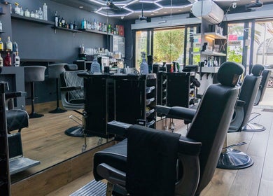Modern barbershop interior at PLAN B | BALLUTA in Sliema, MT, showcasing stylish seating and contemporary design.