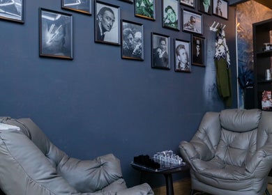 Stylish lounge with plush seats at PLAN B | BALLUTA, Sliema, MT, featuring framed art on dark walls.