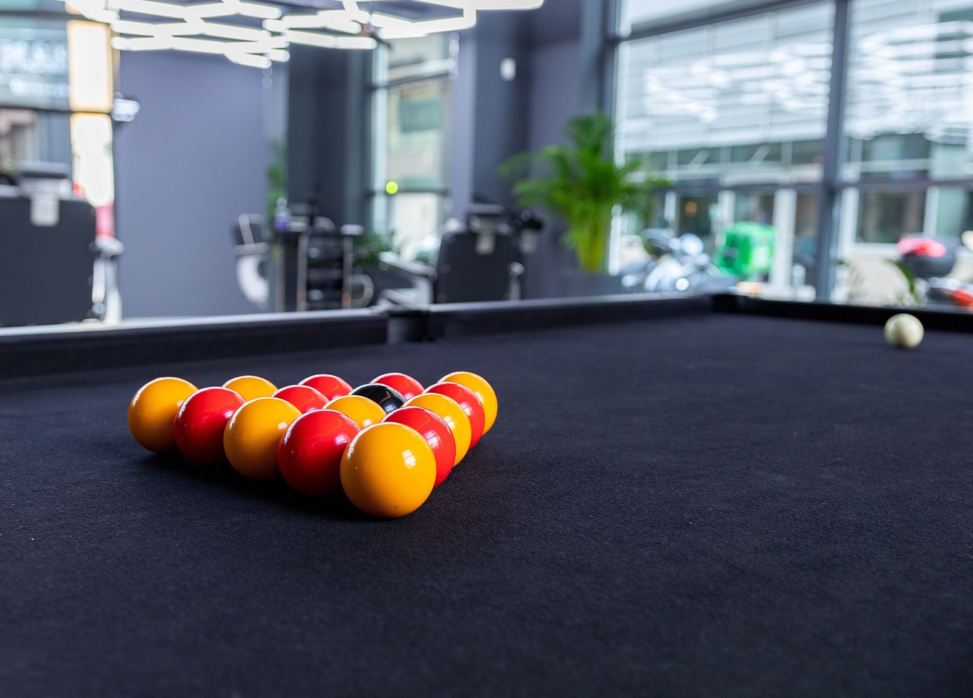 Stylish billiards table at PLAN B | Mercury (St. Julian’s), San Ġiljan, MT with vibrant balls on black felt.