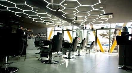 Modern barber chairs at PLAN B | THE STRAND, Tas-sliema, MT. Stylish interior with hexagonal ceiling lights.