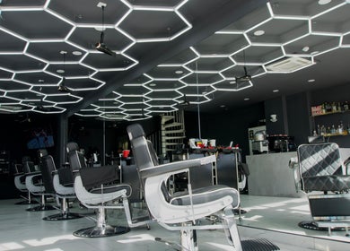 Stylish salon at PLAN B | THE STRAND in Tas-sliema, MT, featuring sleek chairs and geometric lighting.