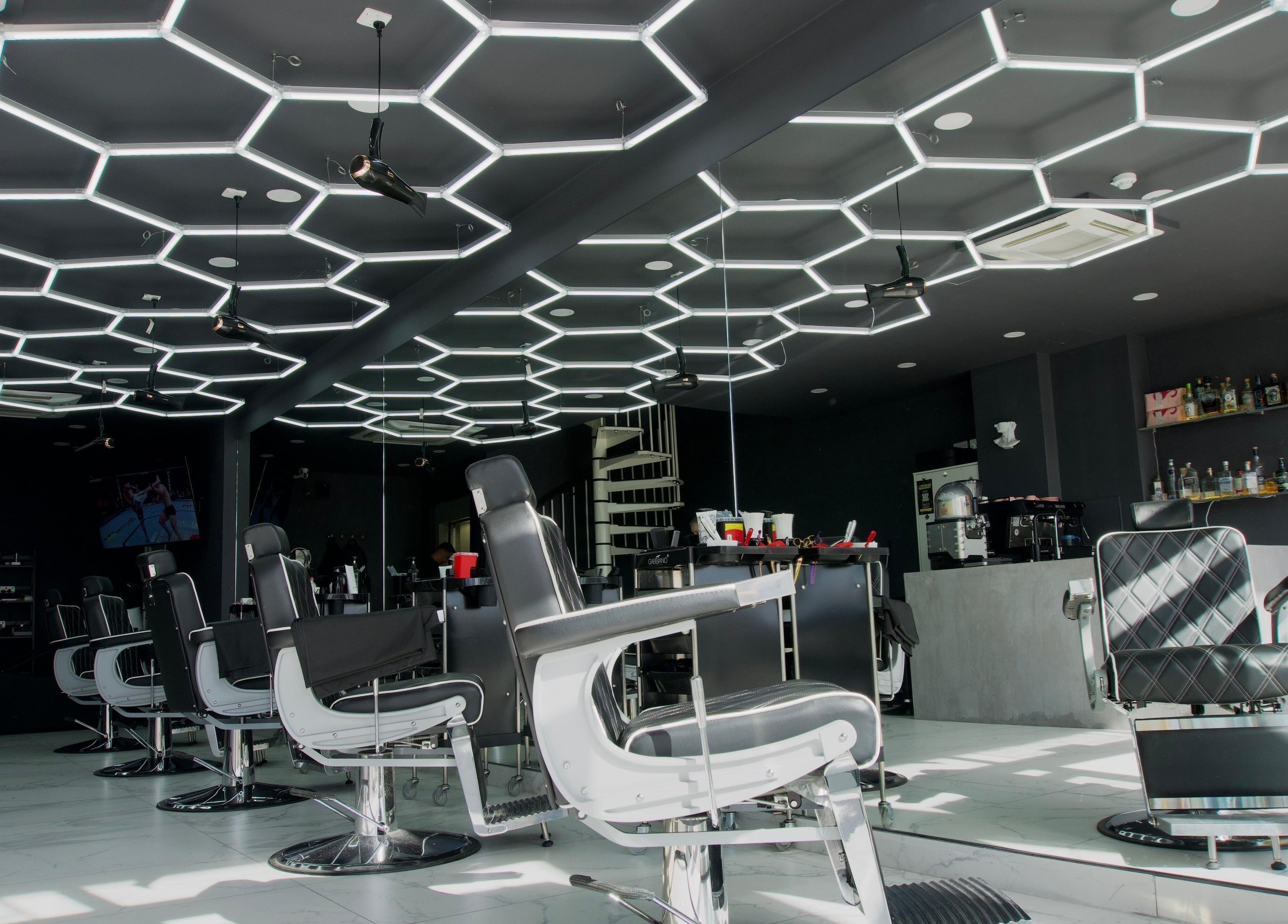 Stylish salon at PLAN B | THE STRAND in Tas-sliema, MT, featuring sleek chairs and geometric lighting.