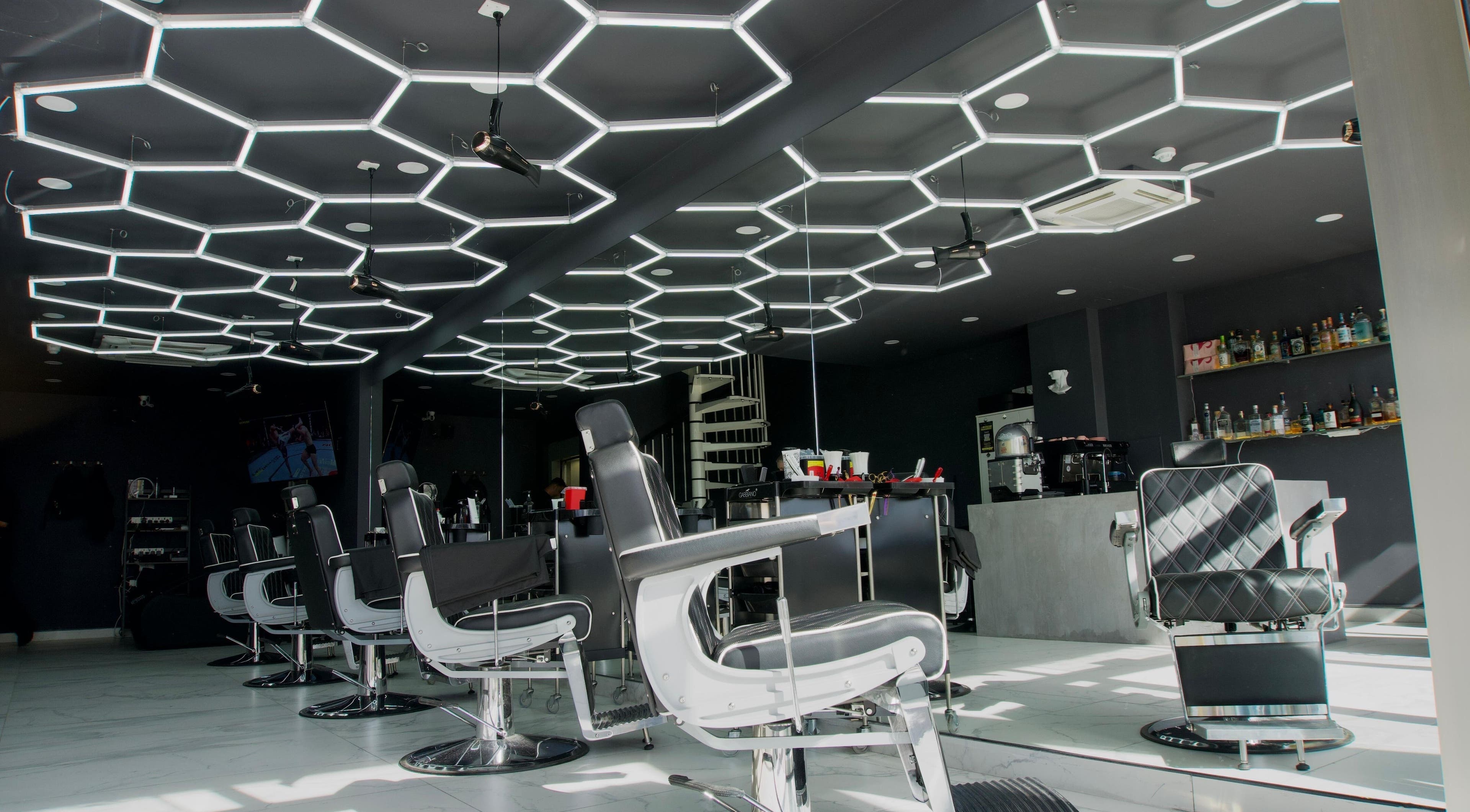 Stylish salon at PLAN B | THE STRAND in Tas-sliema, MT, featuring sleek chairs and geometric lighting.