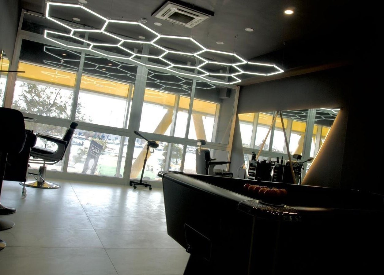 Sleek interior of PLAN B | THE STRAND in Tas-sliema, MT with modern lighting and barber chairs.