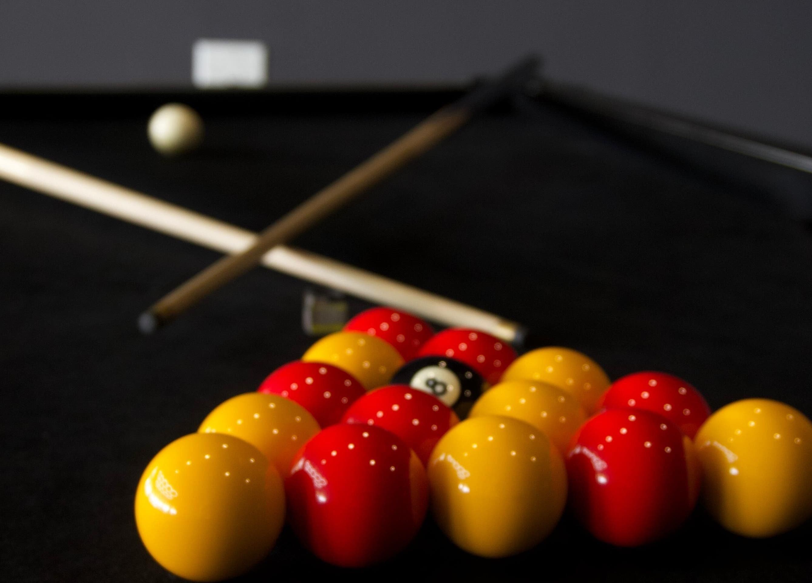 Billiards setup at PLAN B | THE STRAND, Tas-sliema, MT, showcasing vibrant red and yellow balls on a pool table.