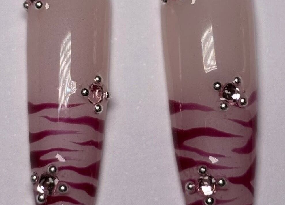 Elegant nail art with pink zebra stripes and rhinestones at SetbyFloss, London, England, GB.