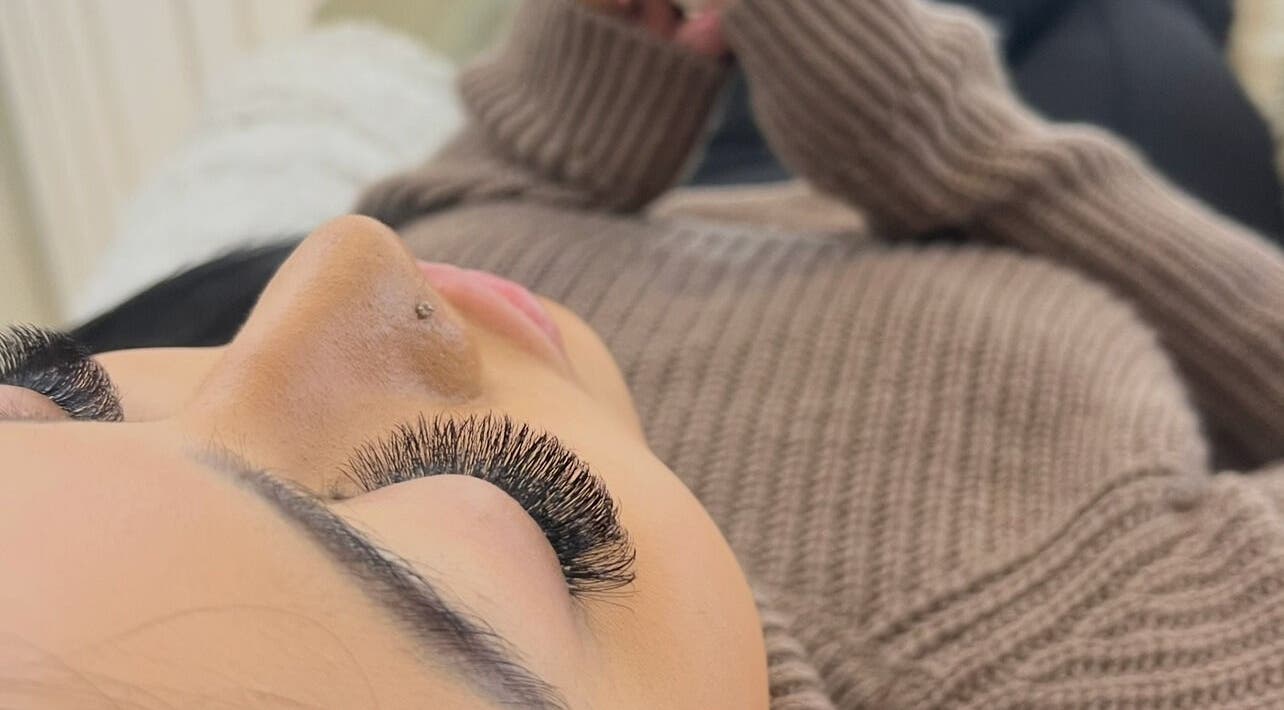 Eyelash extension treatment at Eye Beautify Bondi, Bondi Junction, New South Wales, AU. Woman in cozy sweater.