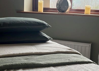 Tranquil massage room at Hummingbird Haven, Bray, County Wicklow, IE with plush bedding and candles.