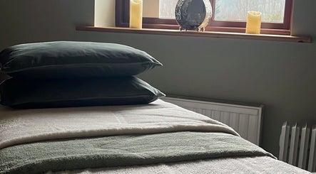 Tranquil massage room at Hummingbird Haven, Bray, County Wicklow, IE with plush bedding and candles.